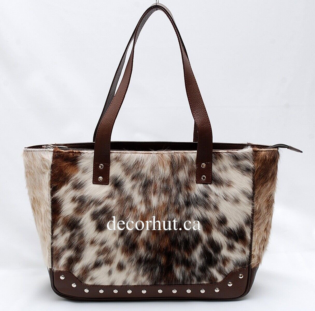 This unique, stylish bag is perfect for the modern fashionista. Handcrafted with natural cowhide, this brown and white bag offers timeless fashion with a contemporary edge.