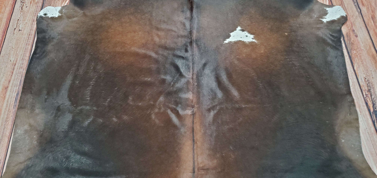 This natural authentic cowhide rug adds warmth, texture, and neutral elegance to any room. Its dark brown and black colors bring modern style to any home.