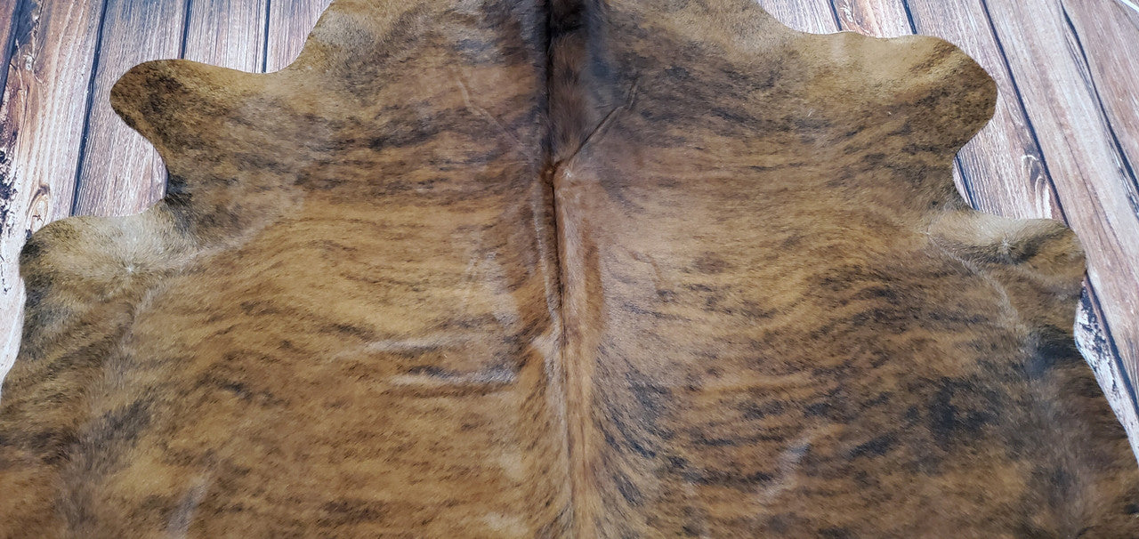 Make a statement with this stunning and exotic brown brindle cowhide rug! Perfect for home staging, it's sure to be the centerpiece of any room - and it's currently trending!
