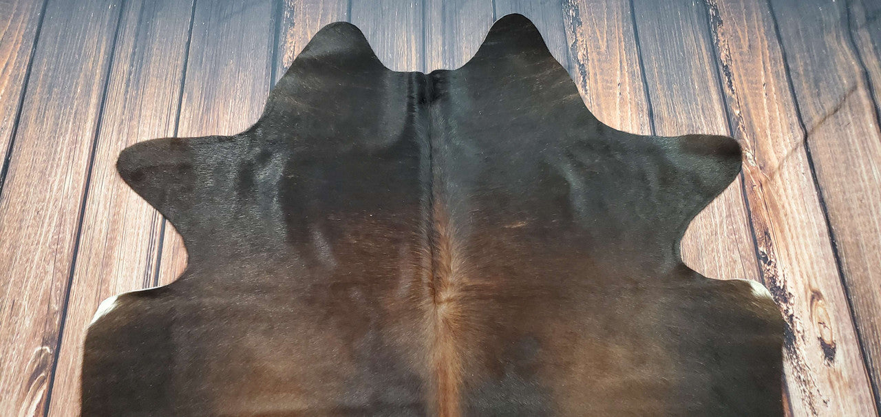Introducing our exquisite dark brindle cowhide rugs - the epitome of sophistication and style for your living space. Crafted from the finest quality cowhides, these rugs are a unique blend of rich chocolate brown and luxurious black tones that will effortlessly elevate any room's decor. 