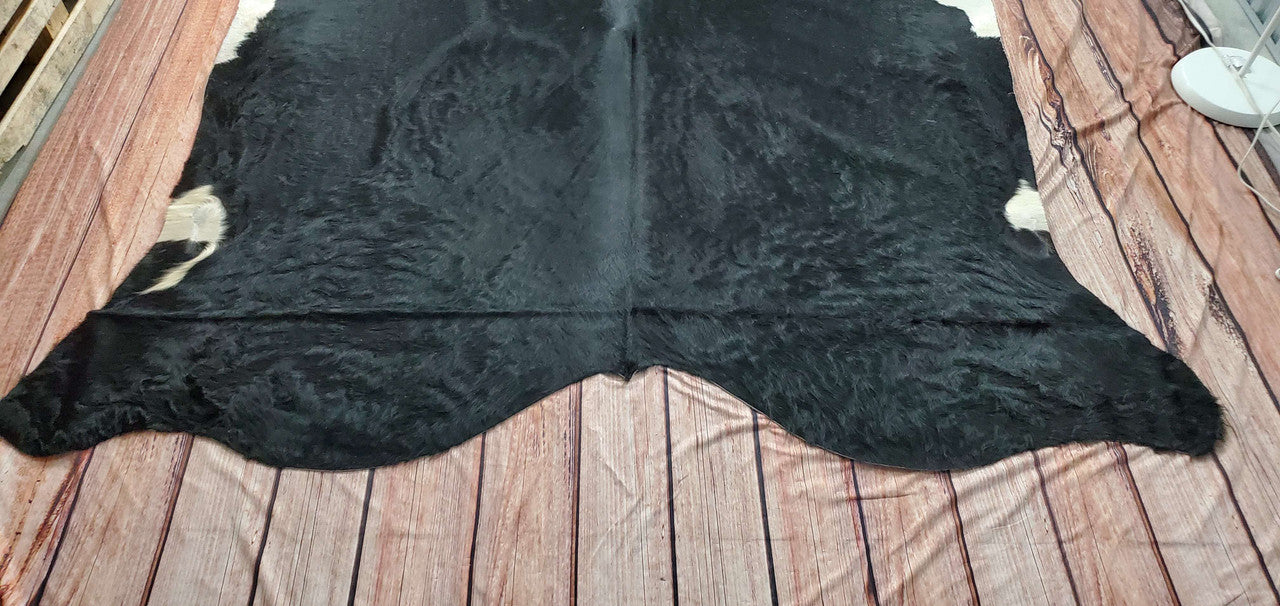 A very lovely, natural, and strong Brazilian black and white cowhide rug was chosen for the really soft texture of its pattern, which was handcrafted for wonderful comfort and appeal in any interior.