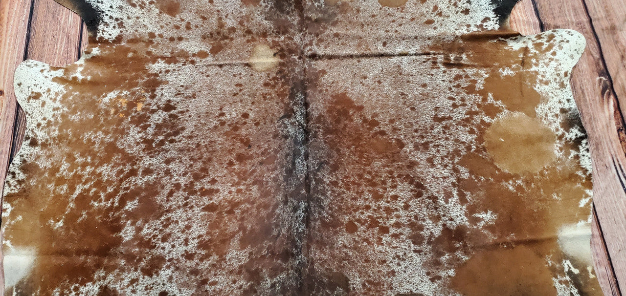 This cowhide rug is composed of tricolor distinct geometric patterns, and well-defined textures.