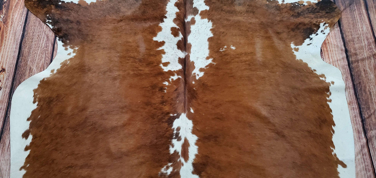 Enhance your living room with this unique cowhide rug! It features dark brown and white hues, making it a charming addition to any space.