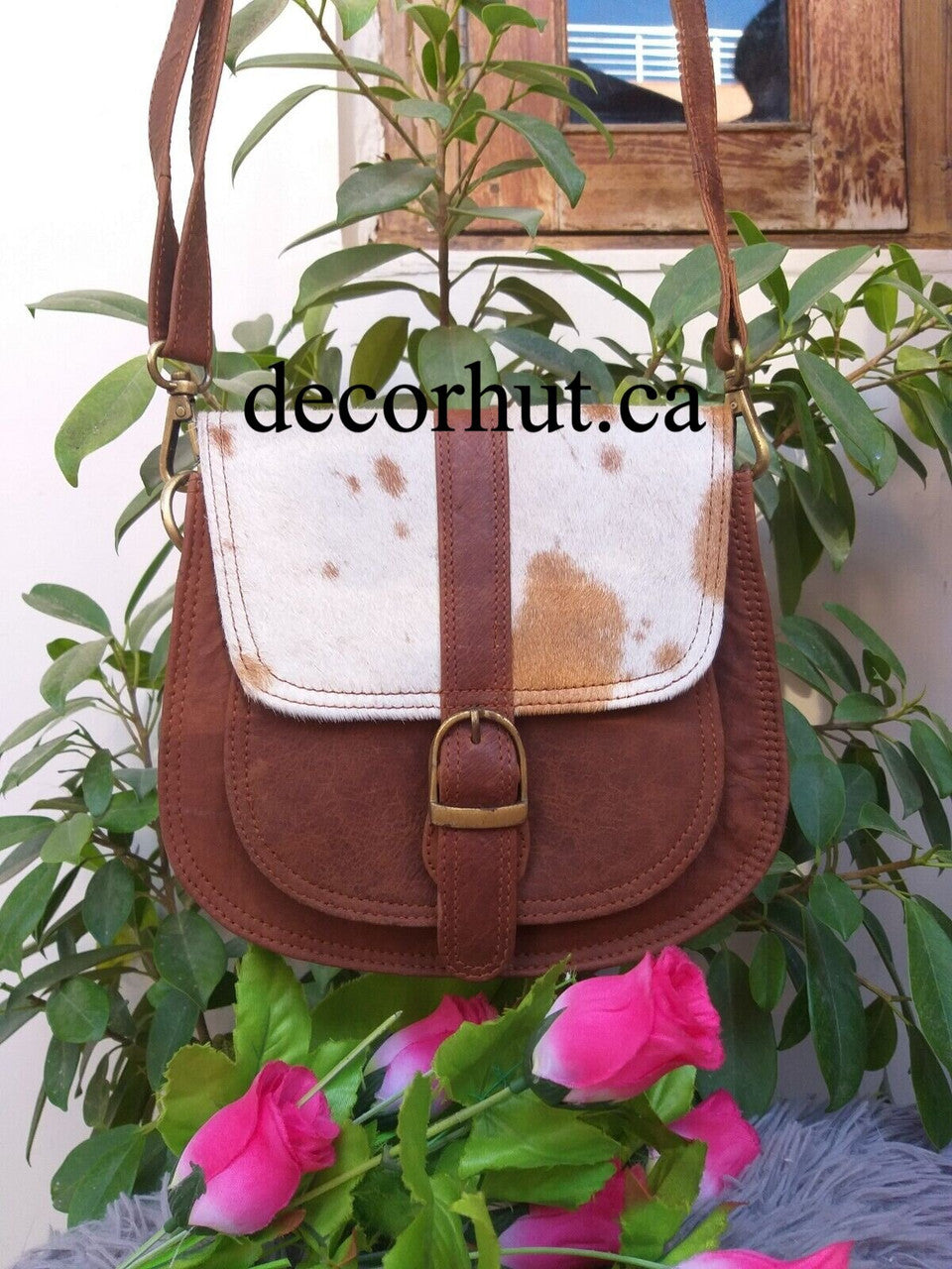 Make a bold statement with this Real Cowhide Purse Handbag! Crafted from genuine leather and featuring a stylish western hair design, adjustable strap and two inside/outside pockets.
