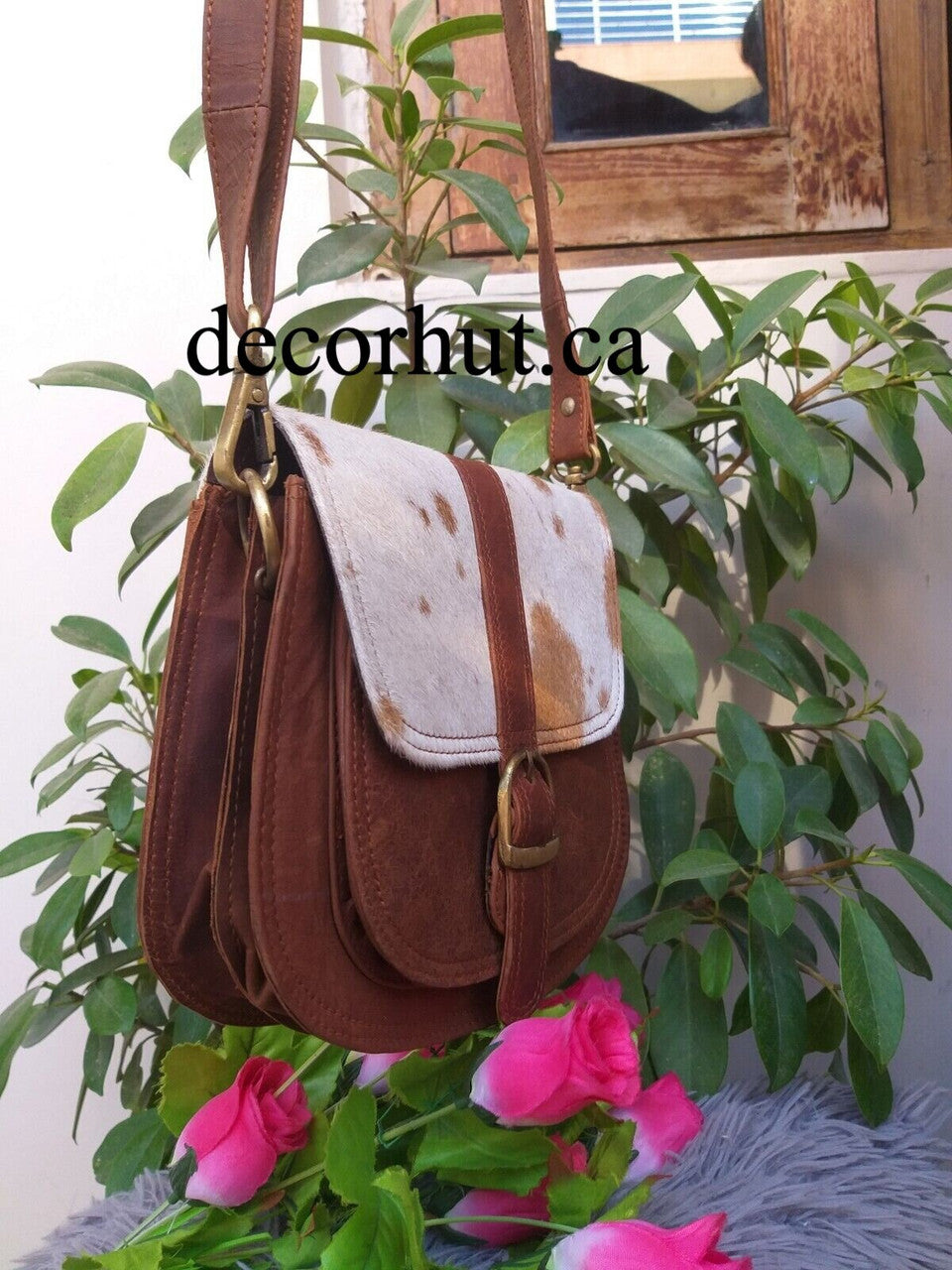 Make a bold statement with this Real Cowhide Purse Handbag! Crafted from genuine leather and featuring a stylish western hair design, adjustable strap and two inside/outside pockets.