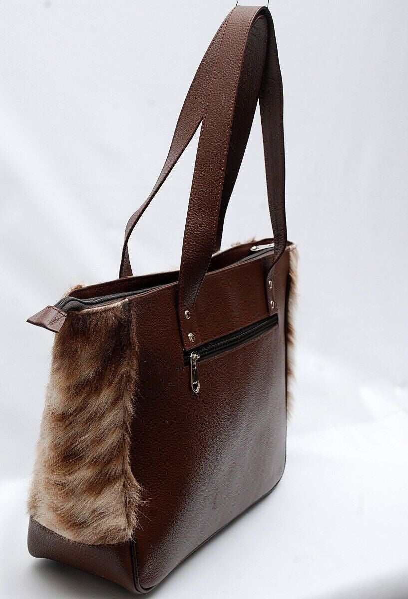 This unique, stylish bag is perfect for the modern fashionista. Handcrafted with natural cowhide, this brown and white bag offers timeless fashion with a contemporary edge.