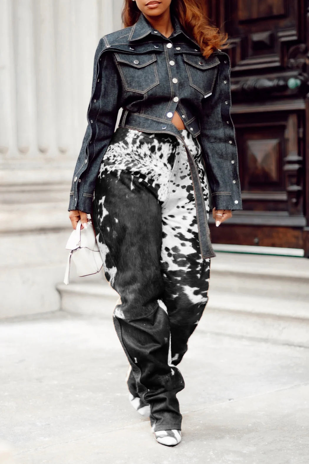 Shop custom women cowhide pants in black and white cow print. Hair on hide trousers with stacked leg fit and natural cow skin leather finish.