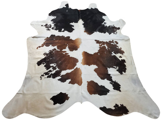 A stunning Tri color cowhide rug large is an exotic mix of spotted speckled brown, black and white, this will look beautiful in the kitchen, farmhouse or modern space.