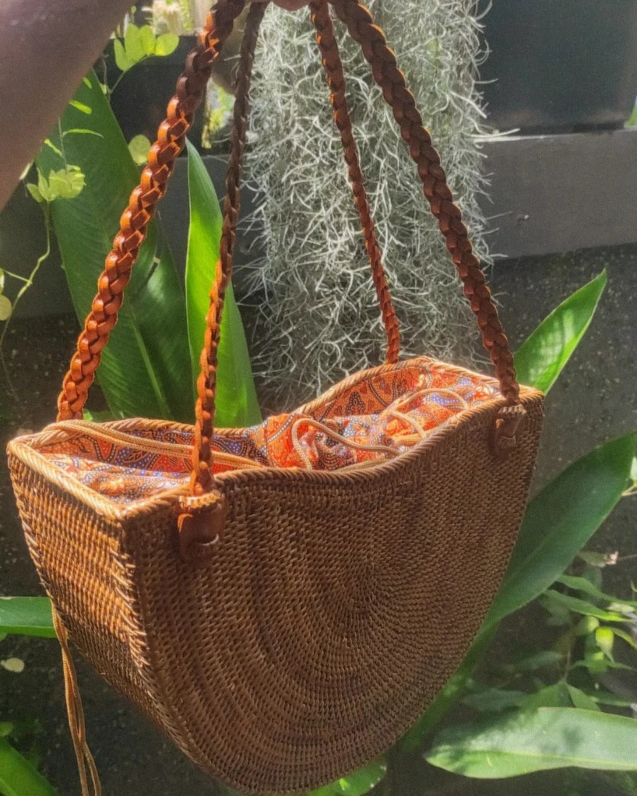 Handgemaakte rieten tas met gevlochten hengsels en kleurrijke batikvoering, ideaal voor zomerse dagen.