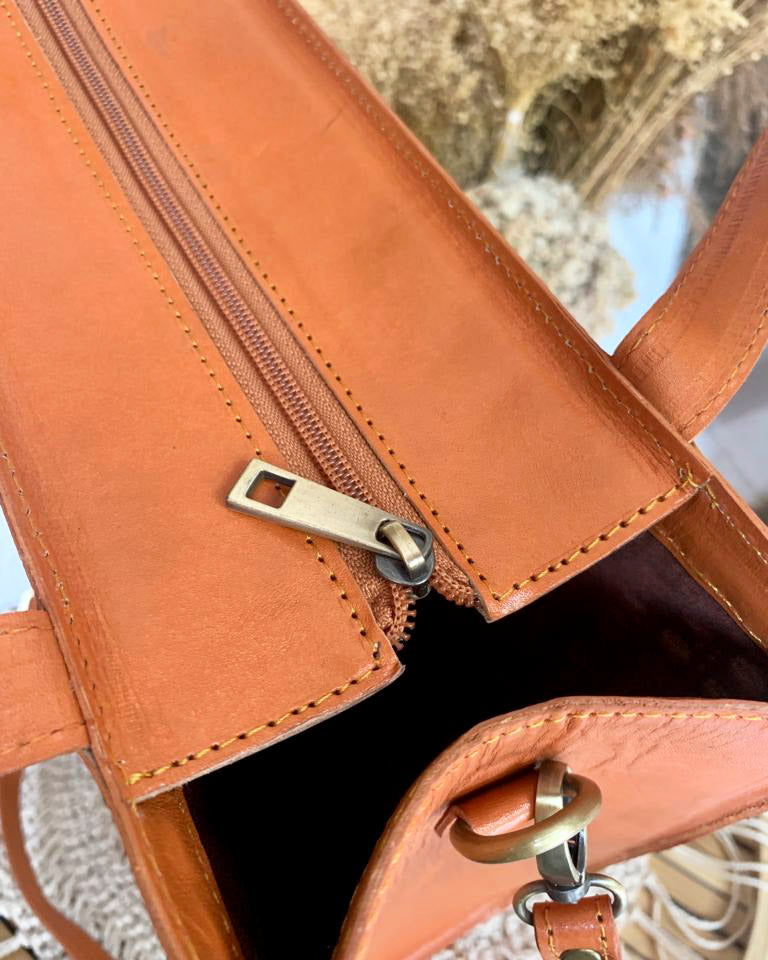 Lichte rattan shopper met verstelbare leren band, geschikt voor reizen en casual gebruik.