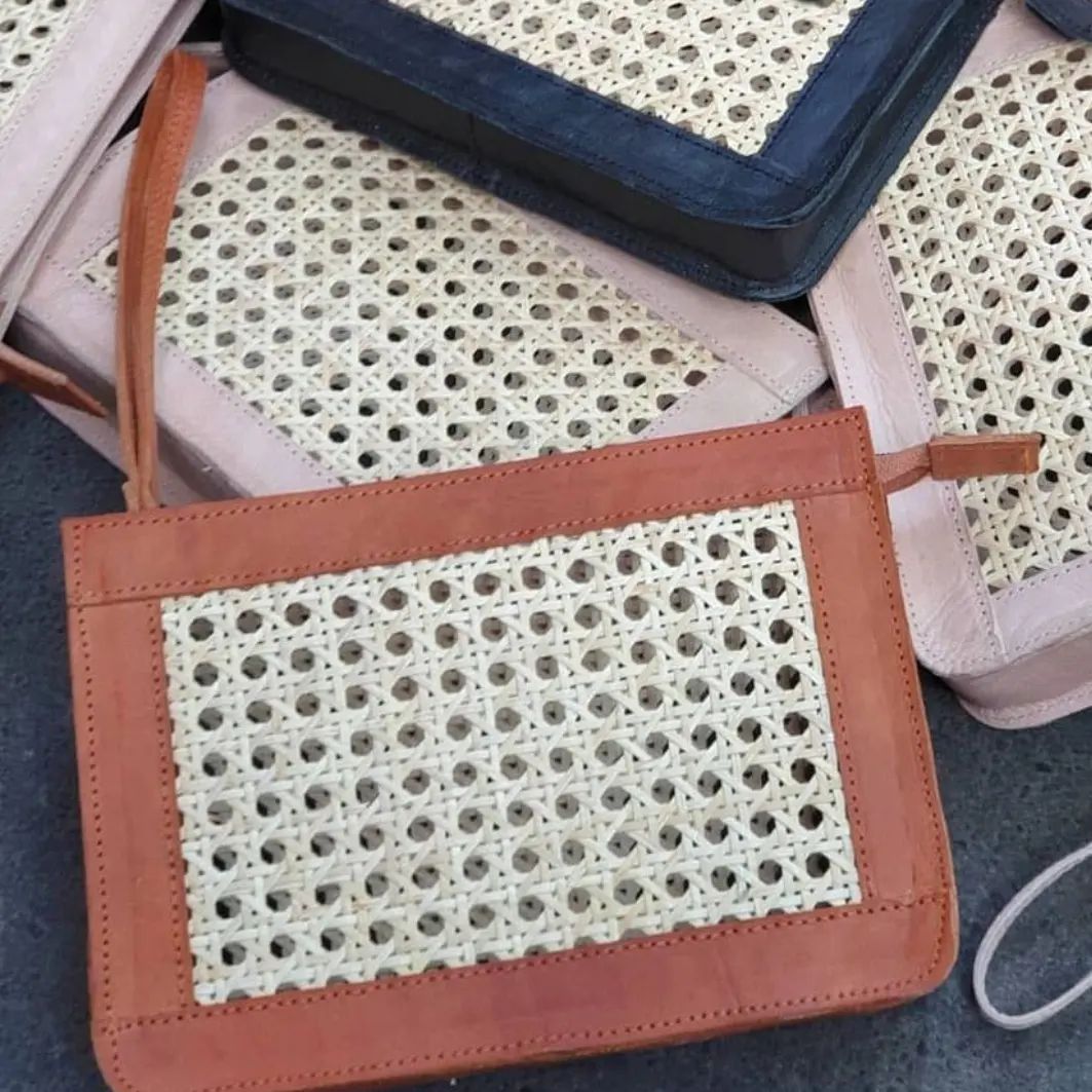Zwei handgefertigte Rattan-Taschen aus Leder nebeneinander vor weißem Korbdisplay