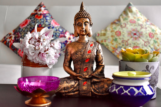 gold buddha figurine on brown wooden table