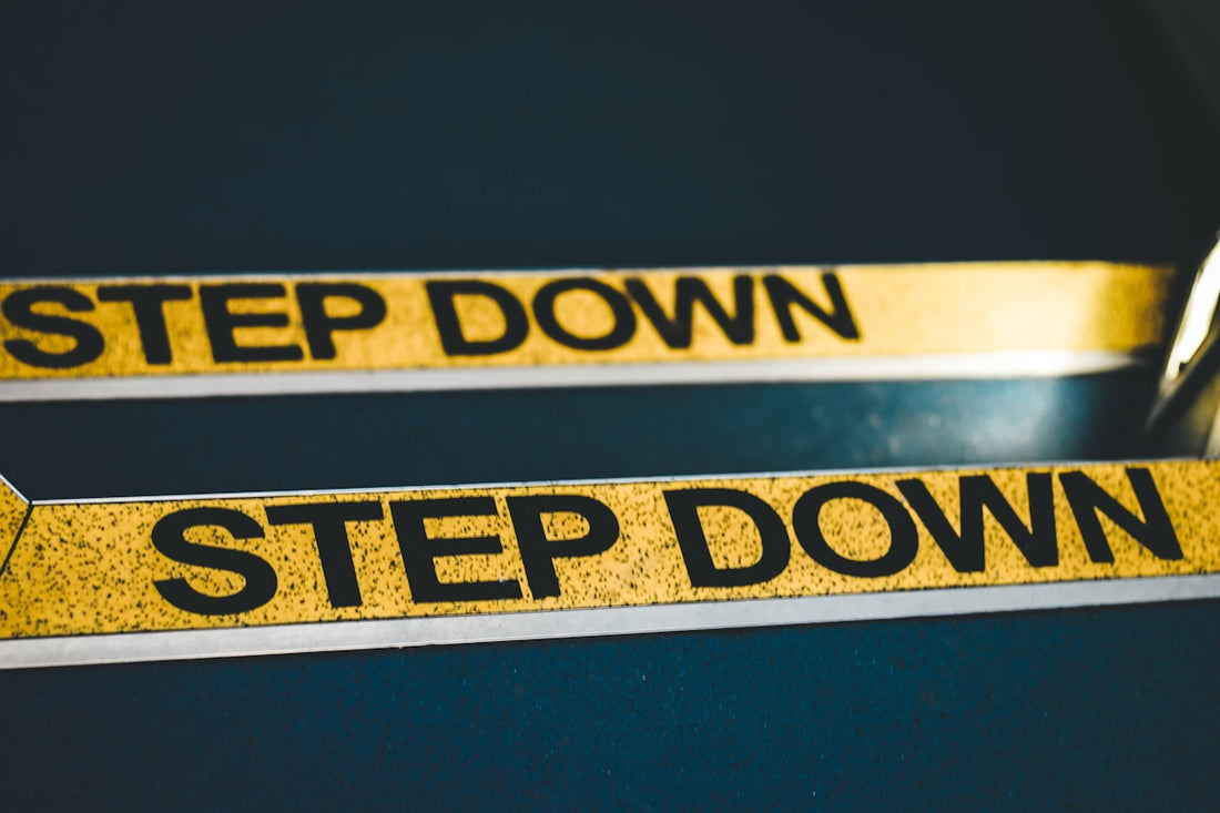 a close up of a pair of scissors near a step down sign