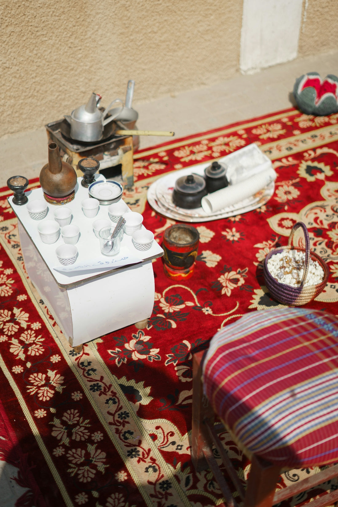 a table topped with a tray of condiments on top of a red rug