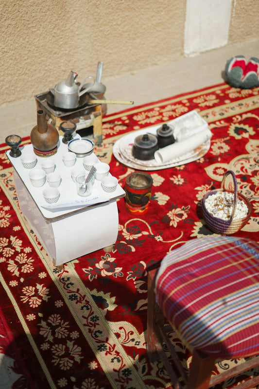 a table topped with a tray of condiments on top of a red rug