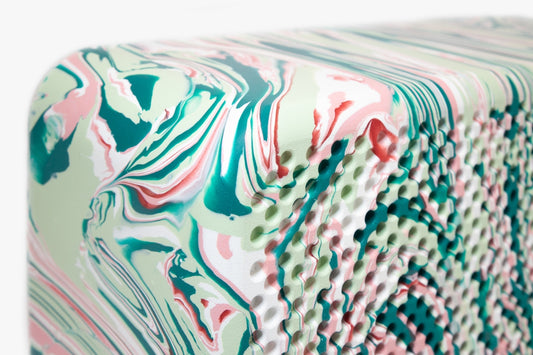 a close up of a piece of art on a white surface