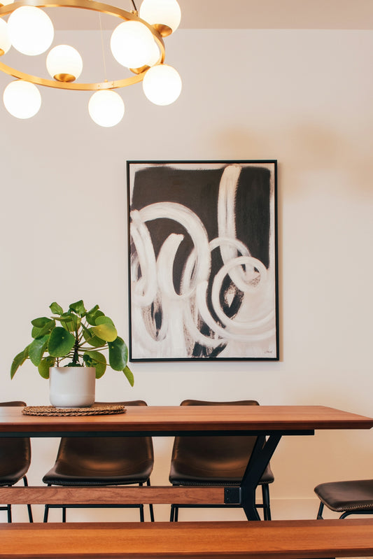Modern dining room with abstract art and plant.