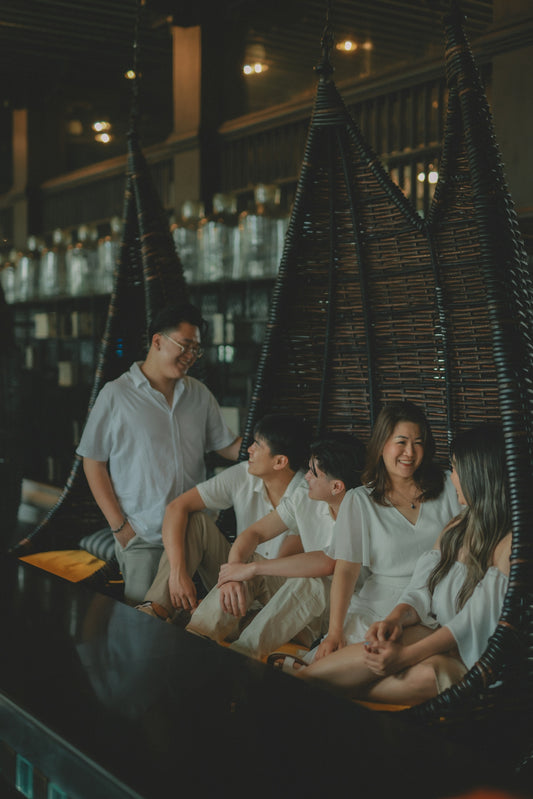 A family relaxes in hanging chairs indoors.