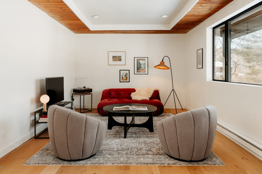 Modern living room with red sofa and grey chairs.