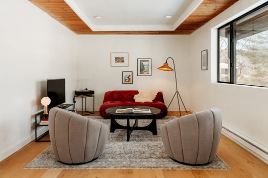 Modern living room with red sofa and grey chairs.