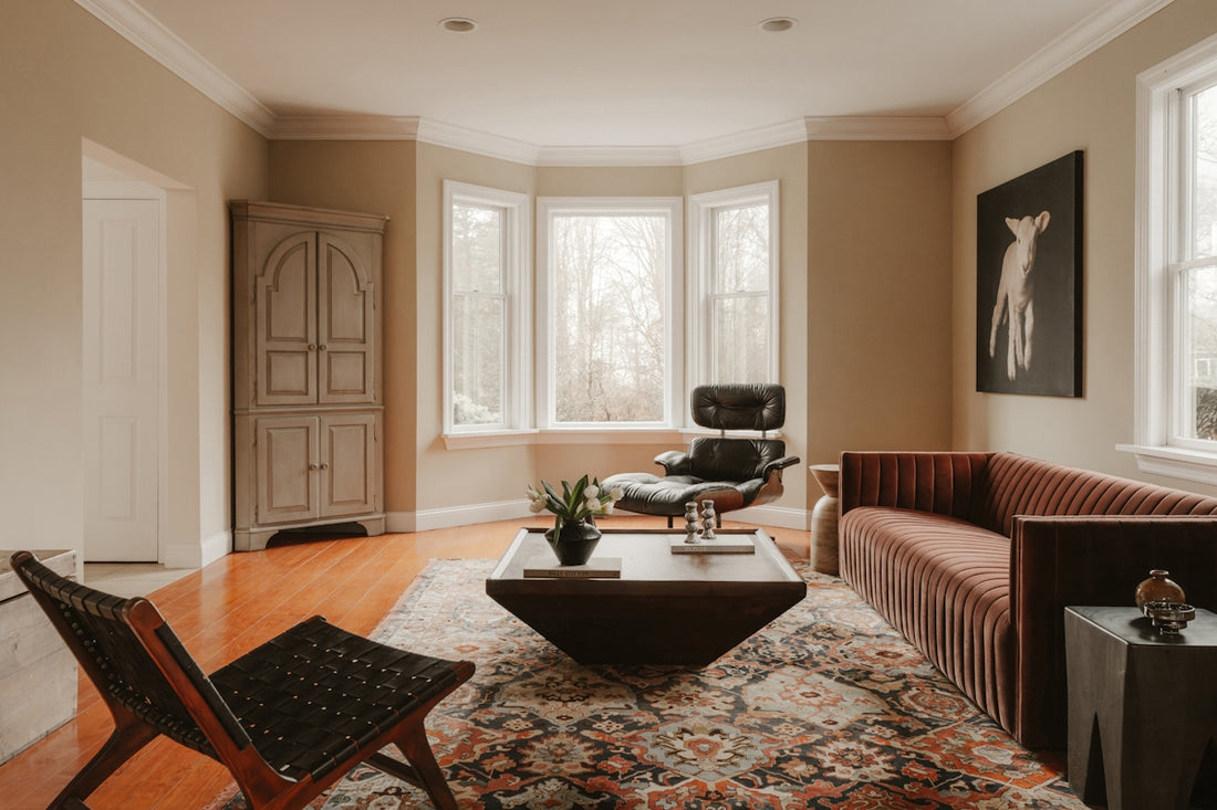 Modern living room with stylish furniture and large windows.