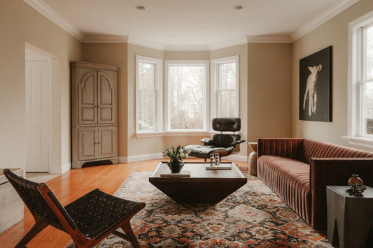 Modern living room with stylish furniture and large windows.