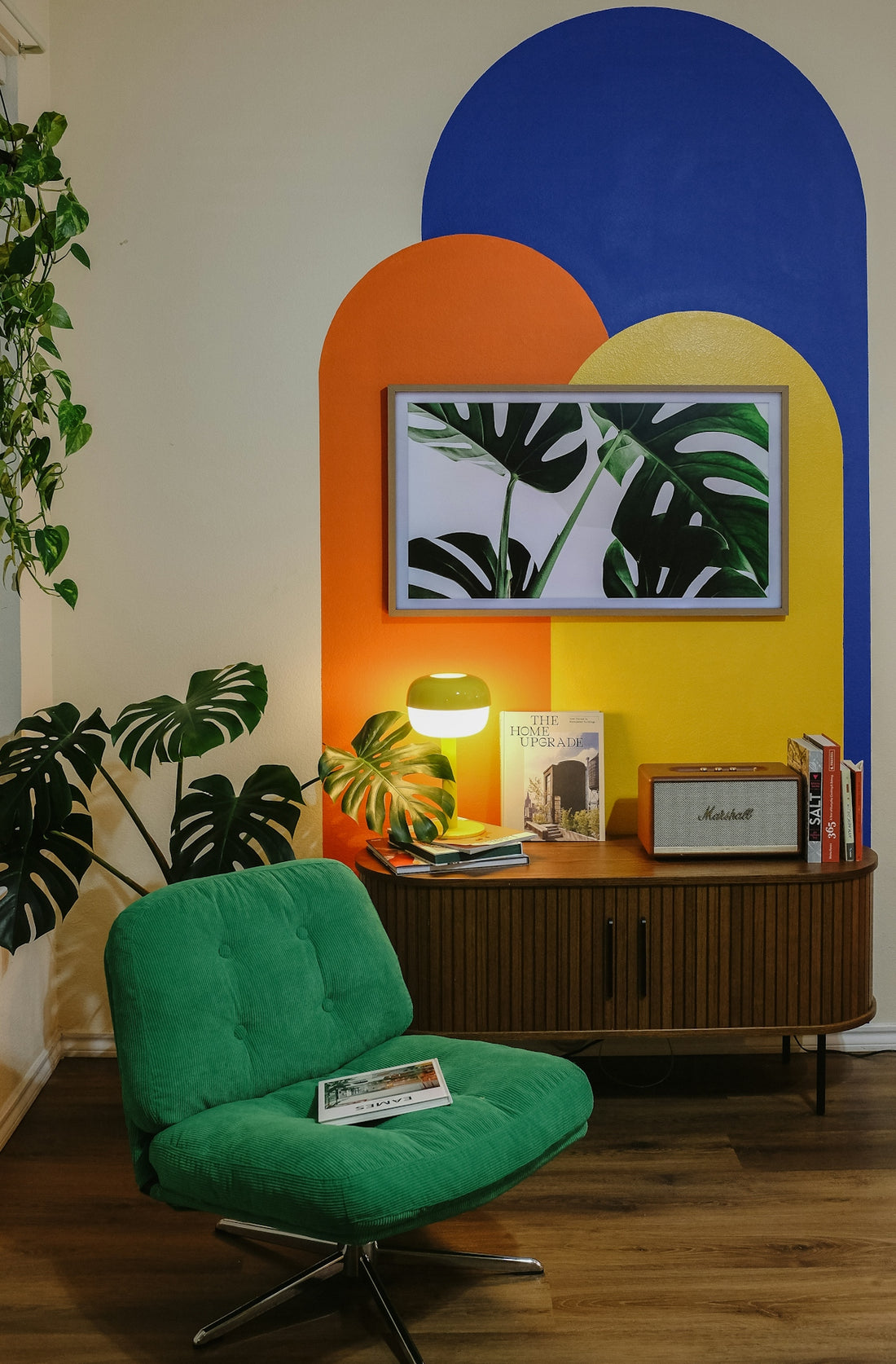 Green chair and retro cabinet with colorful wall art