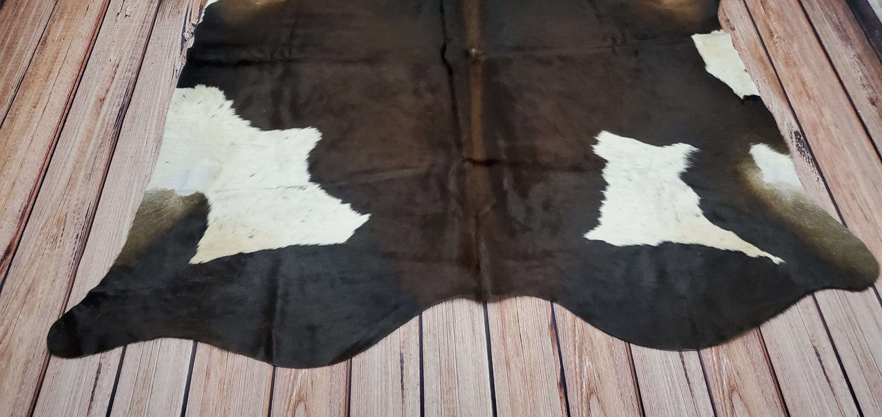 This large cowhide rug is one of its kind, an exotic mix of dark brown, black and white, whether it's rustic or chic, look no further.