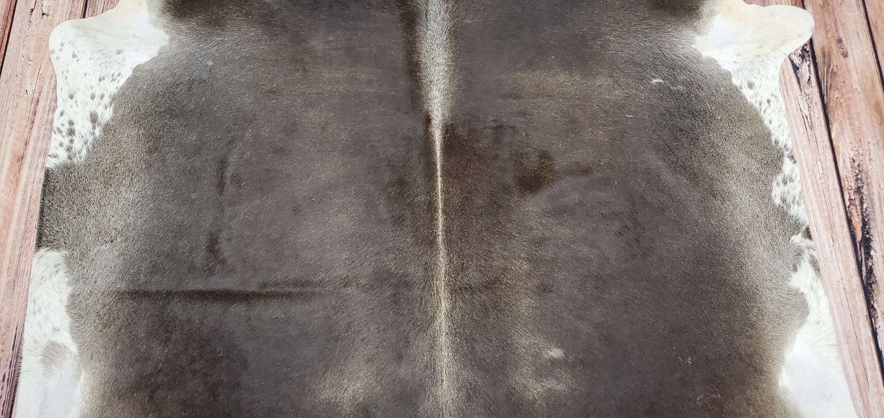 Make any light space look chic and exotic with this authentic, dark Brazilian cowhide rug! Sumptuous texture and warm tones make it perfect for any living room or bedroom. 