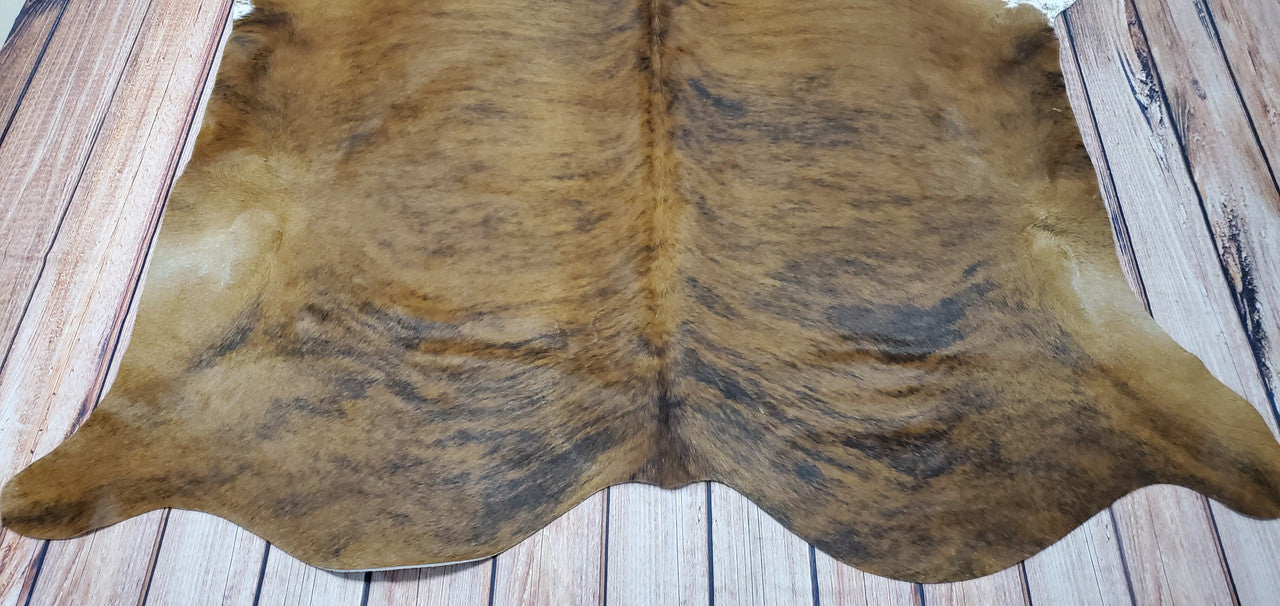 A tan brindle cowhide rug is the perfect way to add a unique touch of rustic charm to any living space.
