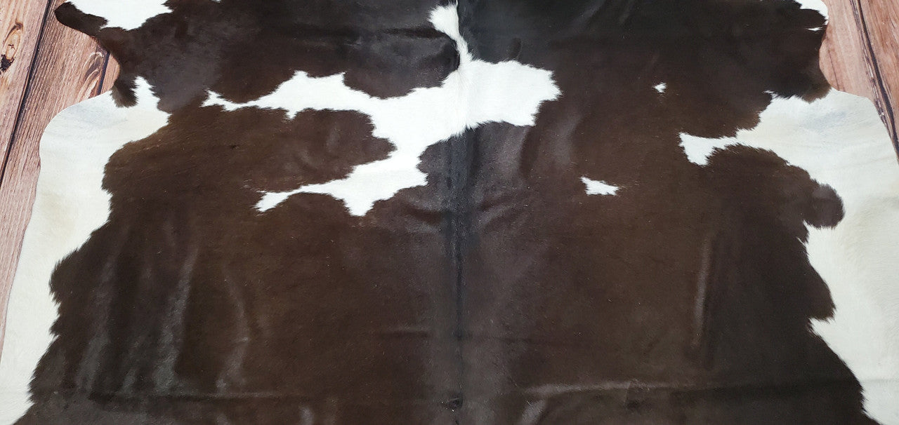Le tapis en peau de vache foncée est incroyable, un chef-d'œuvre absolu