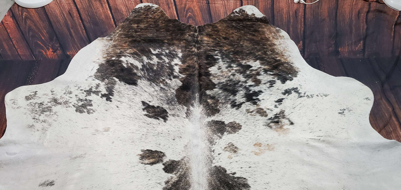 Upgrade your space with a stunning brindle cowhide rug. Its unique pattern and soft texture will make a bold statement in any room. 