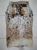 Detail van handgemaakte koeienprint rok met metalen knopen en stevige tailleband.

