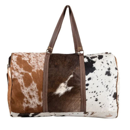 This cowhide duffel bag or weekender purse features a sturdy adjustable shoulder strap as well as two short handles for easy carrying. The exterior flap pocket provides secure storage space for documents and other items that require quick access.