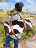 Versatile cowhide bag suitable for both men and women, on a bench.