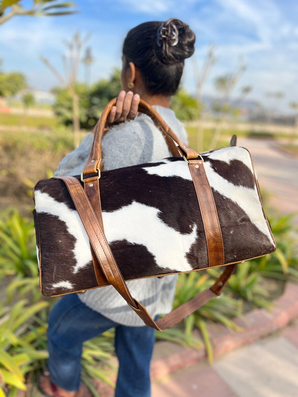 Versatile cowhide bag suitable for both men and women, on a bench.