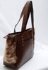 This unique, stylish bag is perfect for the modern fashionista. Handcrafted with natural cowhide, this brown and white bag offers timeless fashion with a contemporary edge.