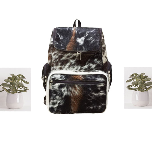 This one of a kind speckled cowhide backpack is sure to turn heads. It's handmade with traditional stitching and features a spacious interior, perfect for carrying your everyday essentials in style.