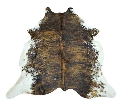 A mostly coffee brown and white cowhide rug with beautiful speckles in the background. We select each cowhide for its exotic patterns and natural markings. 