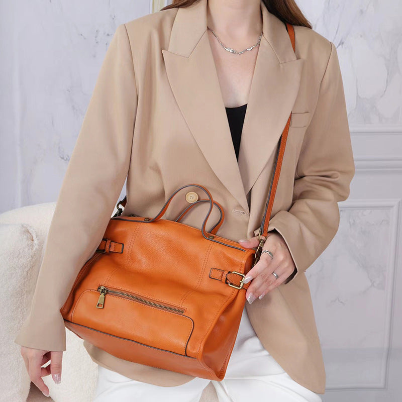 Cowhide leather women crossbody bag with top handle, spacious interior, and clean stitched panels