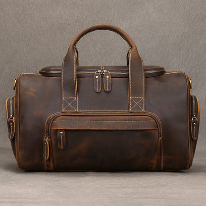 Retro leather duffel bag for men with cowhide body, shoulder strap, and multi-pocket travel layout