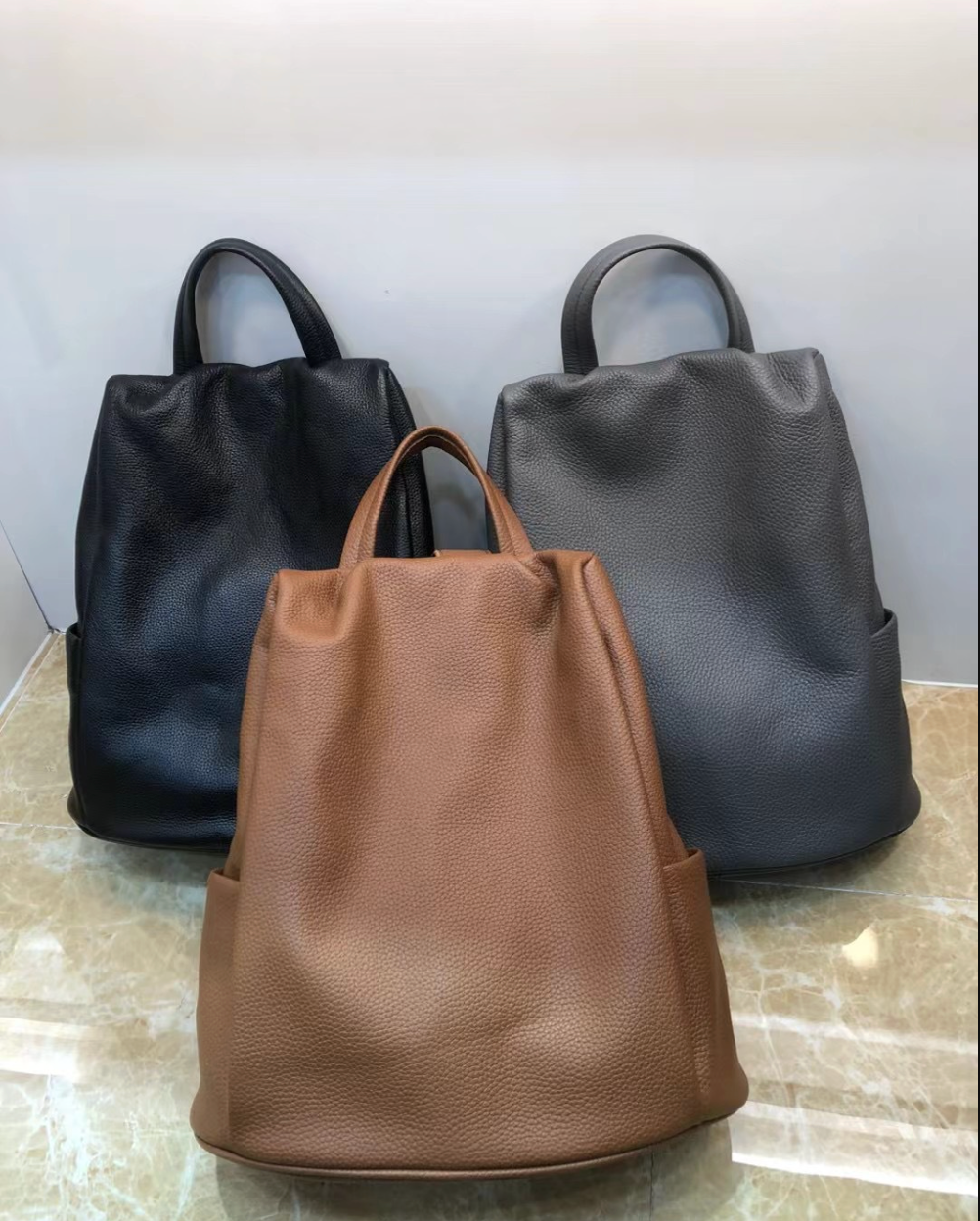 Grey genuine leather backpack tote with dual carry straps, spacious interior, zip closure for daily work and travel