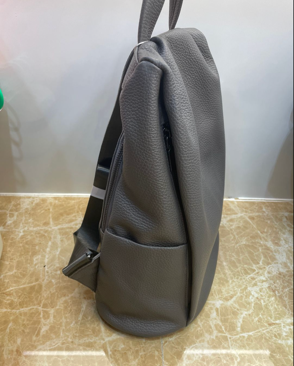 Large leather tote backpack combining top handles and shoulder straps for flexible daily and travel use