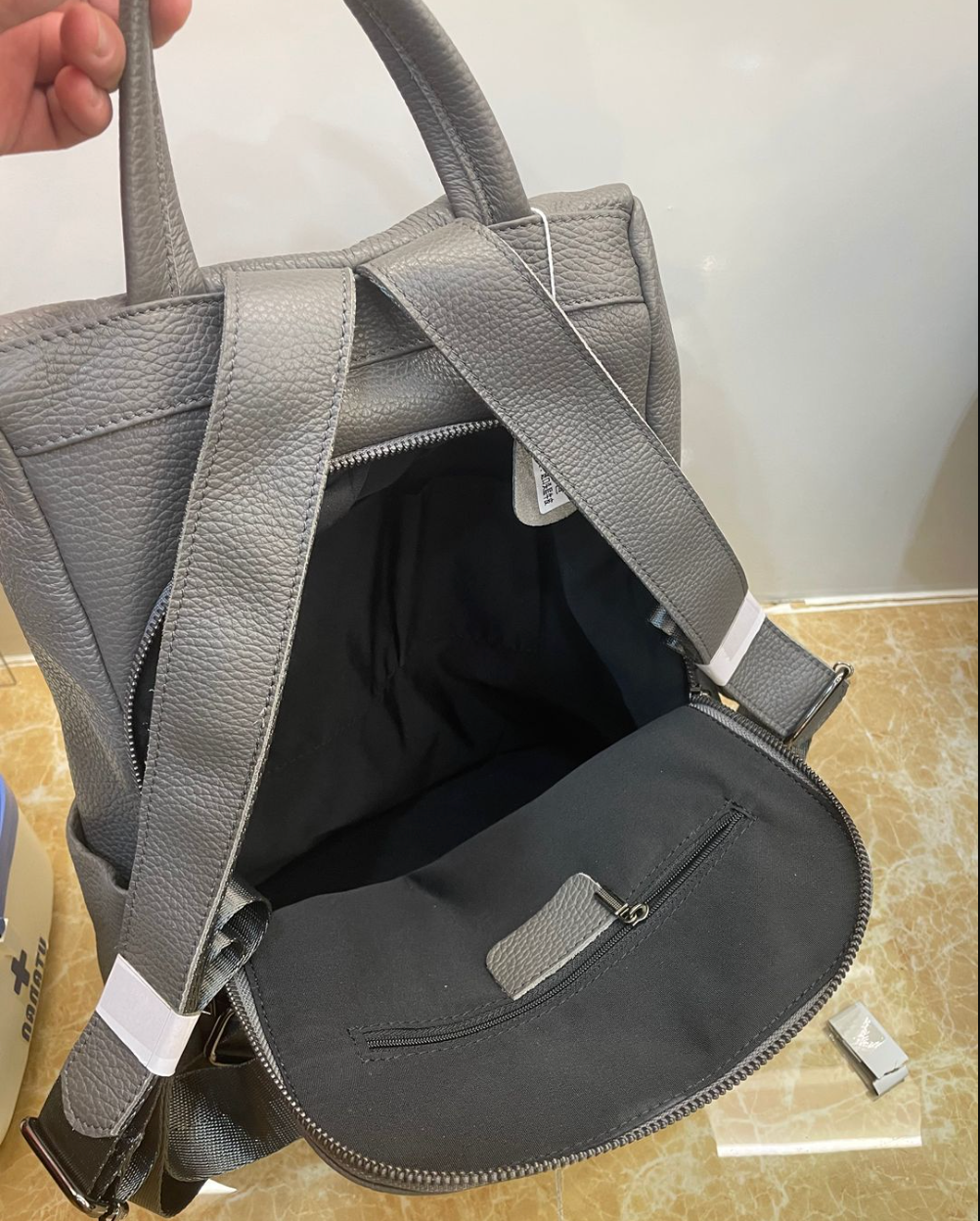 Leather tote backpack featuring top handle carry, adjustable straps, and spacious interior for essentials
