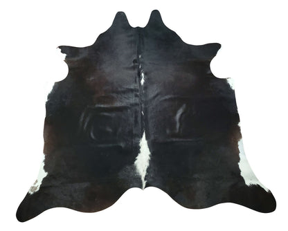 A small black cowhide rug selected for unique style, this will look fabulous in white farmhouse or even a dark lodge