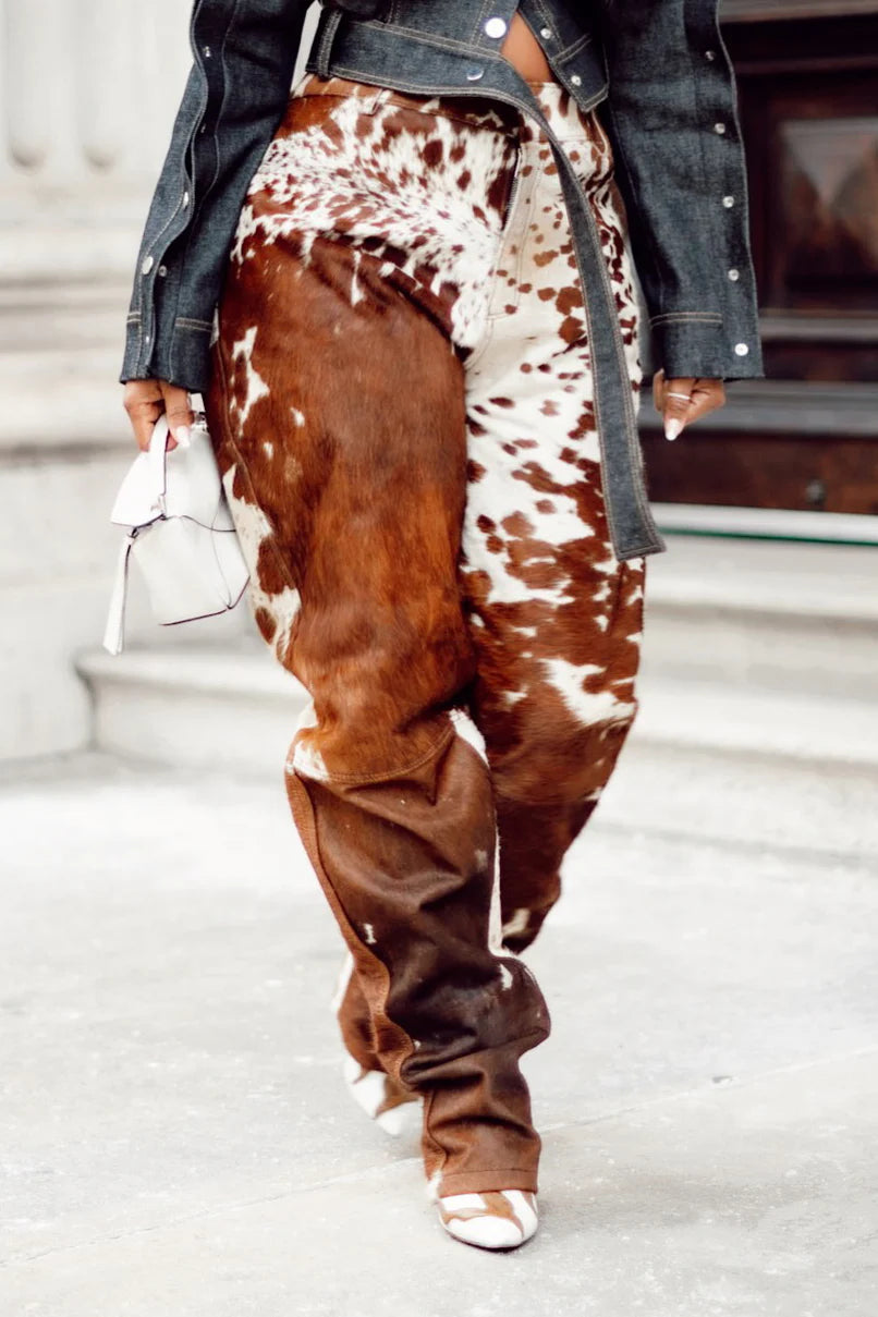 Custom women cowhide pants with brown white cow print. Real hair on hide trousers designed from authentic cow skin for standout fashion styling.