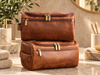 Men's leather toiletry bag open with hanging hook and grooming essentials