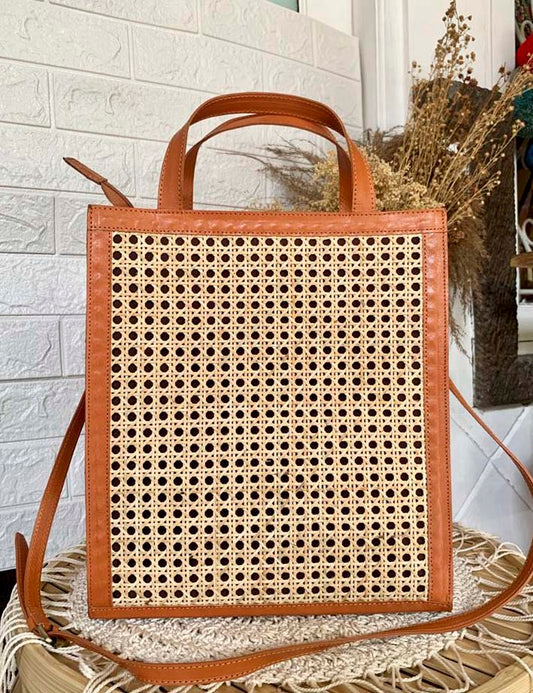 Handgemaakte rieten tas met leren afwerking, ideaal voor stranddagen en zomerse uitstapjes.


