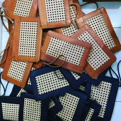 Nahaufnahme der geflochtenen Rattanstruktur und Lederkante der schwarzen Clutch

