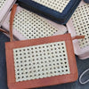 Zwei handgefertigte Rattan-Taschen aus Leder nebeneinander vor weißem Korbdisplay

